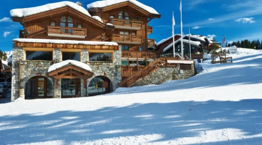 A property manager inspects the snow-covered balcony of a luxury chalet in a French Alpine ski resort.